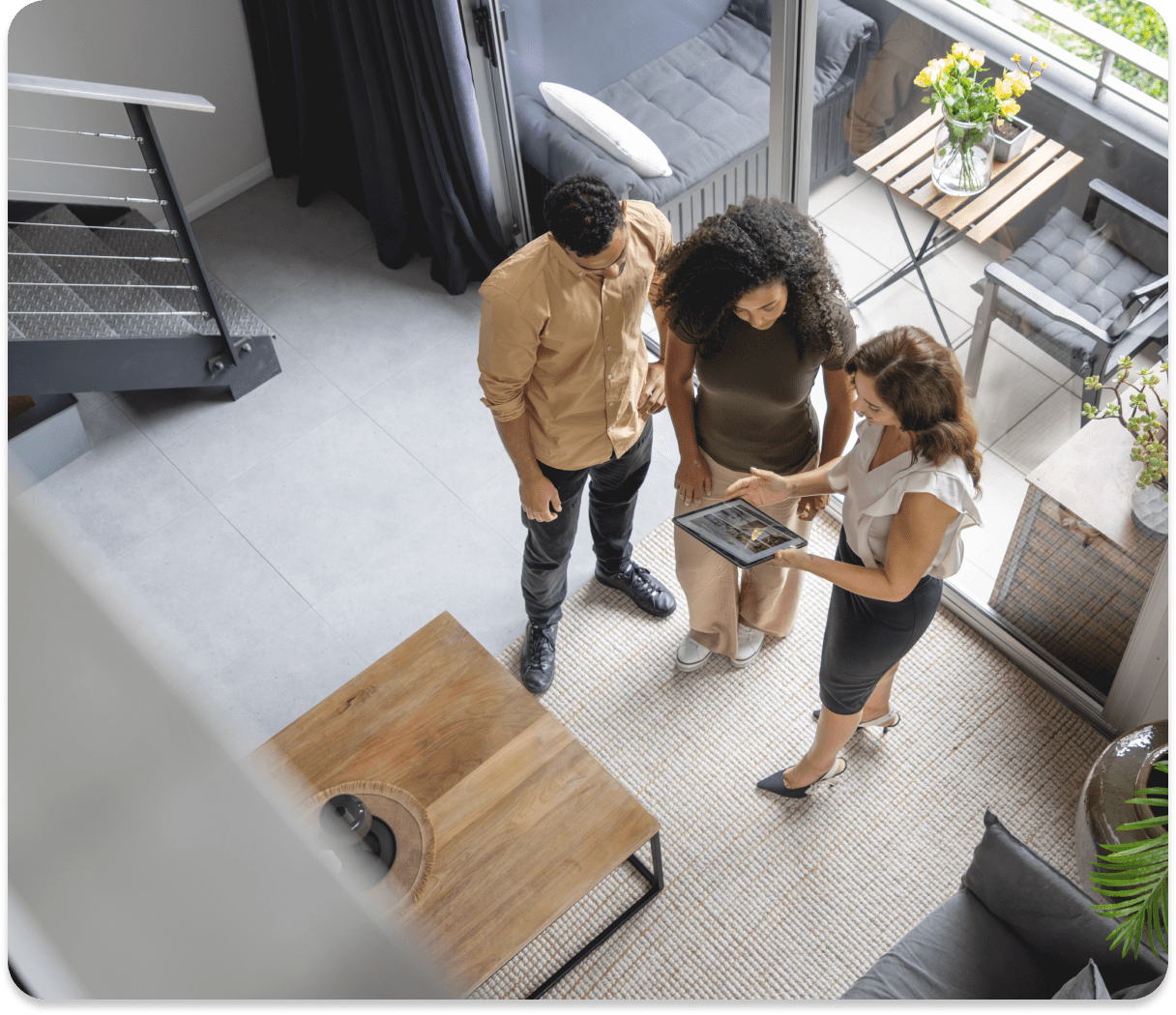 Real estate agent showing tablet to couple.