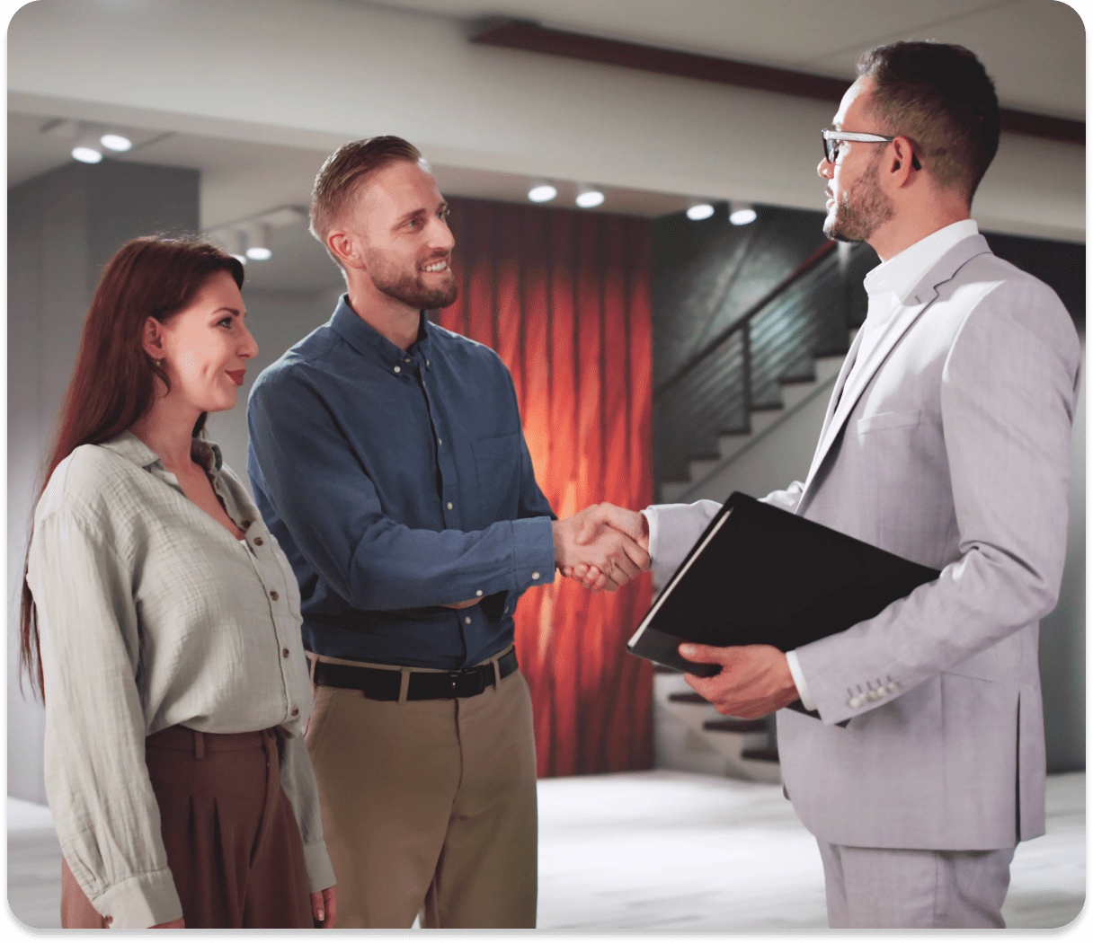Three people shaking hands in modern office.