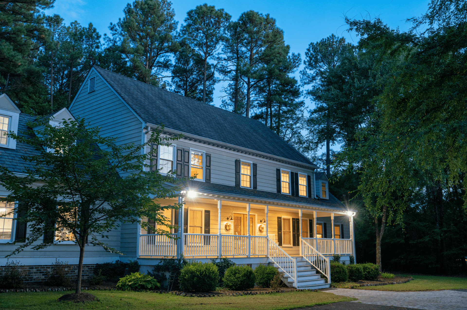 House with porch lights at dusk.